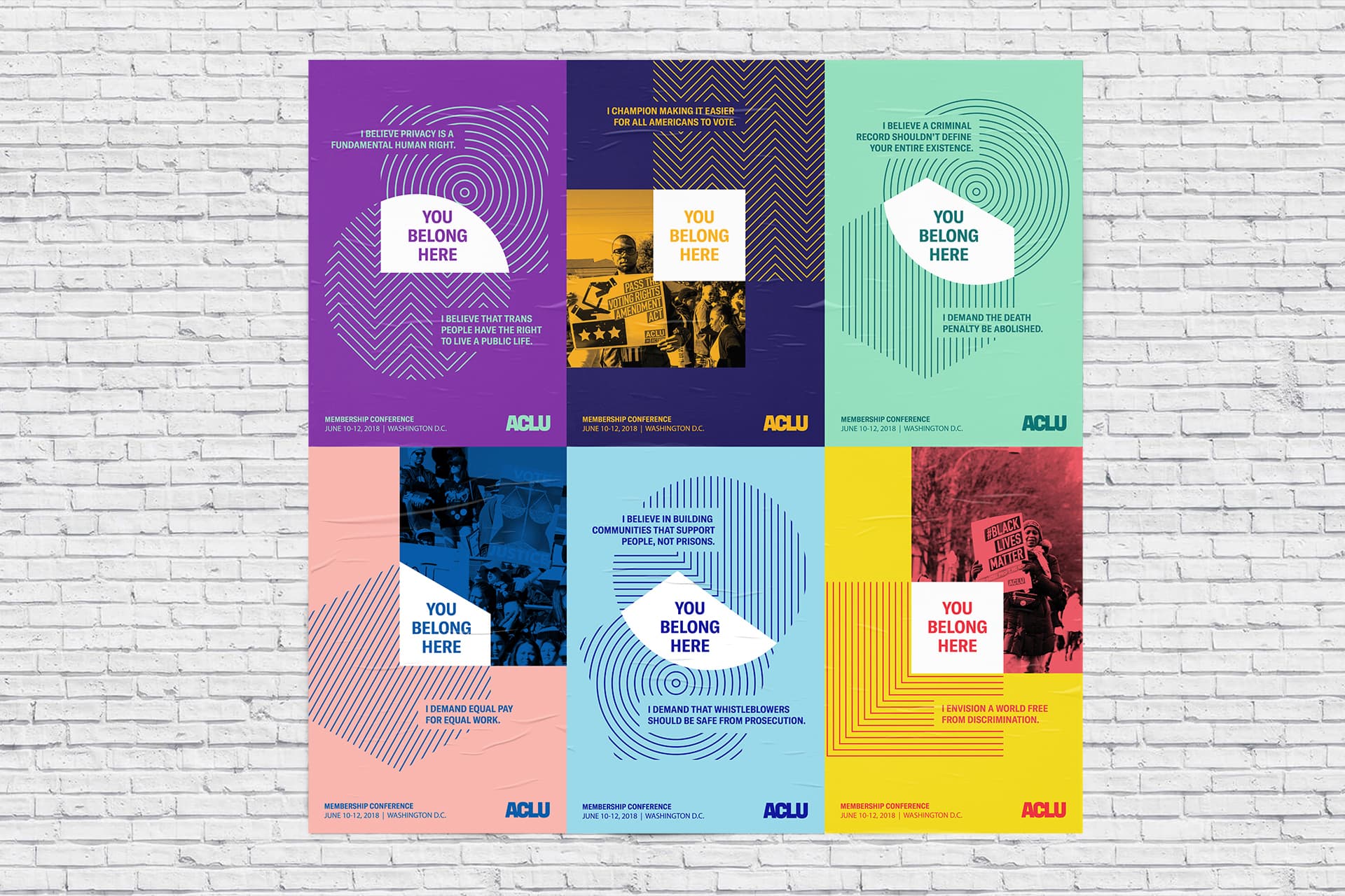 A set of six colorful ACLU posters on a white brick wall, each with a distinctive background design and the message "You Belong Here." The posters promote principles such as inclusivity, activism, civil liberties, and social justice.