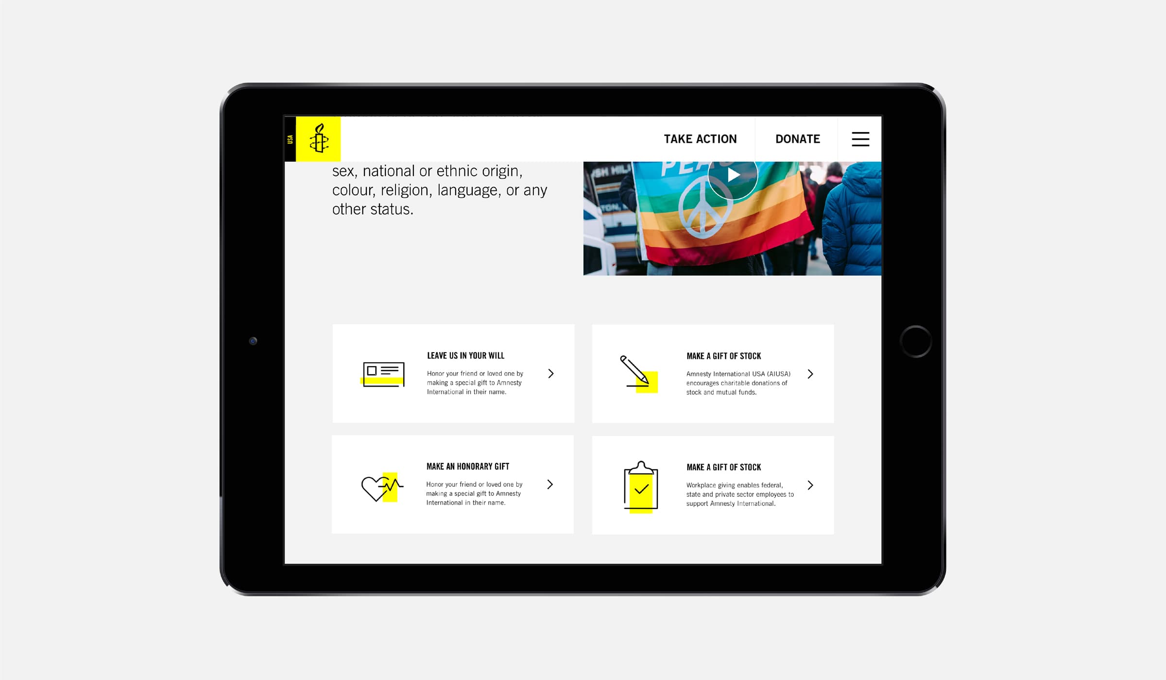 A tablet displaying a webpage from Amnesty International. The page has a banner with a peace and rainbow flag. Below, there are options to send a virtual gift, make an in-memoriam gift, make a gift of stock, and make a year-end stock donation.