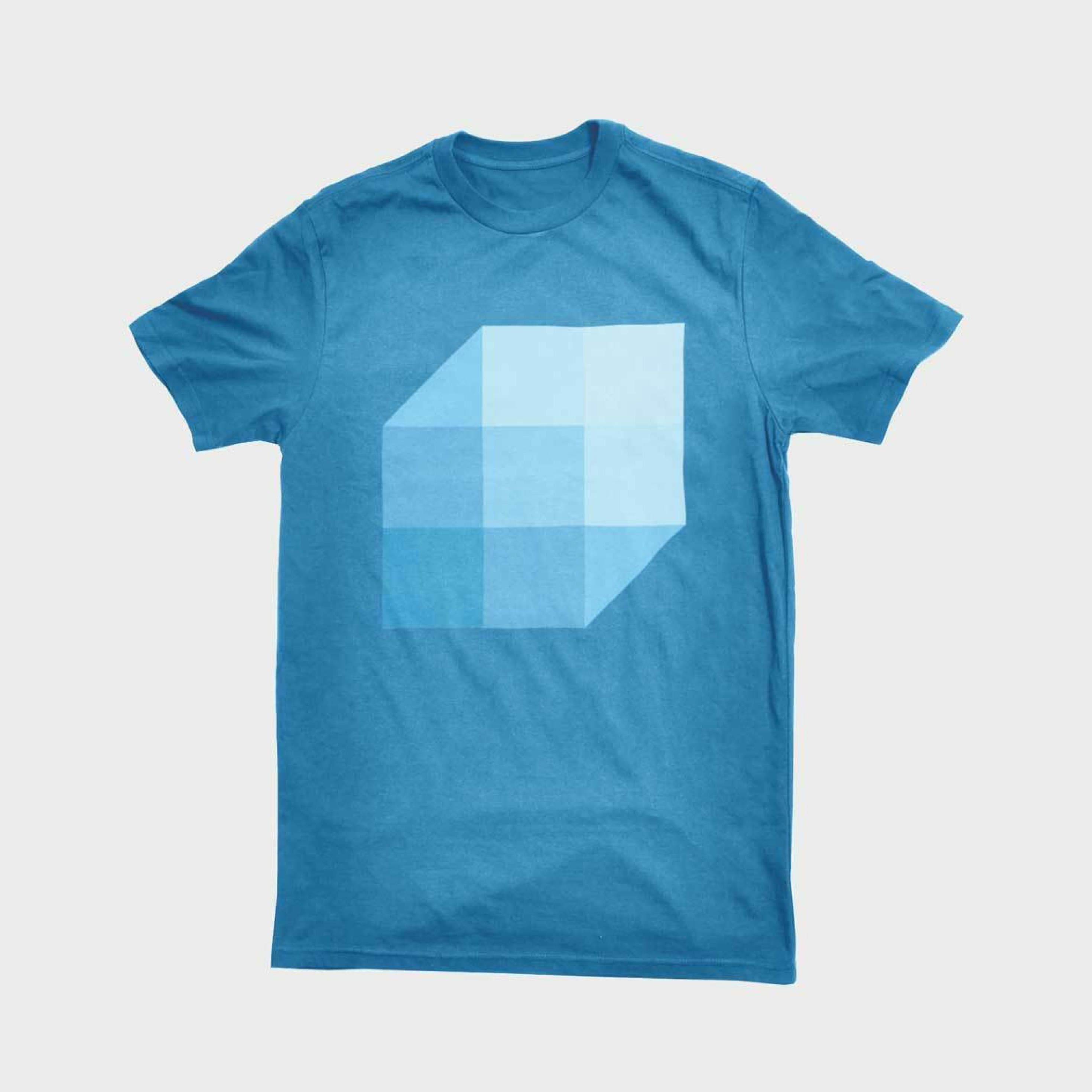 A blue T-shirt featuring a large geometric cube design on the front, composed of different shades of blue to create a three-dimensional effect. The cube is centered on the chest, standing out against the solid blue background of the shirt.