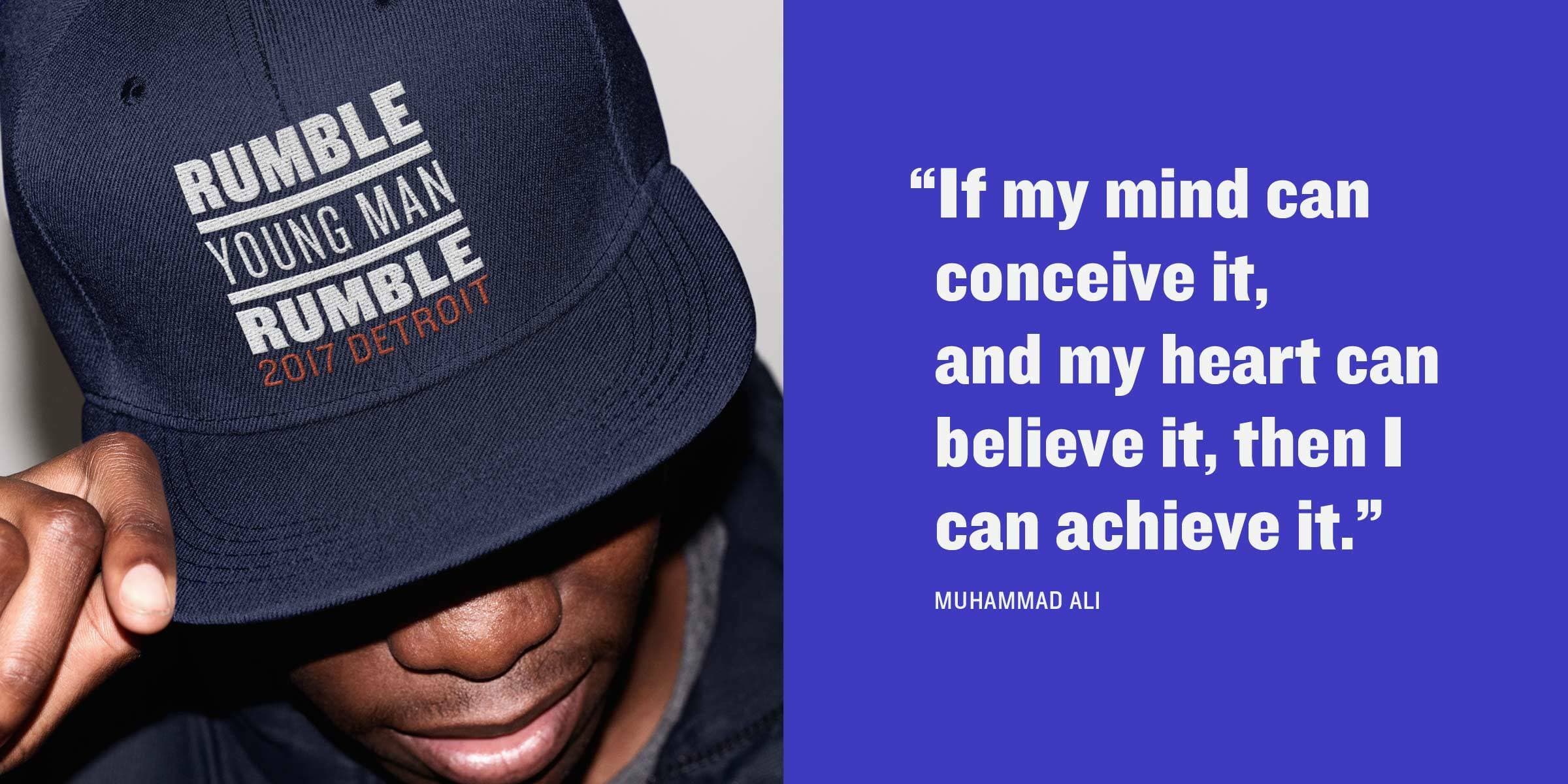 A person wearing a "Rumble Young Man Rumble 2017 Detroit" cap is partially visible, with the brim of the cap covering their eyes. Next to them is a blue background with a white text quote: "If my mind can conceive it, and my heart can believe it, then I can achieve it." - Muhammad Ali.