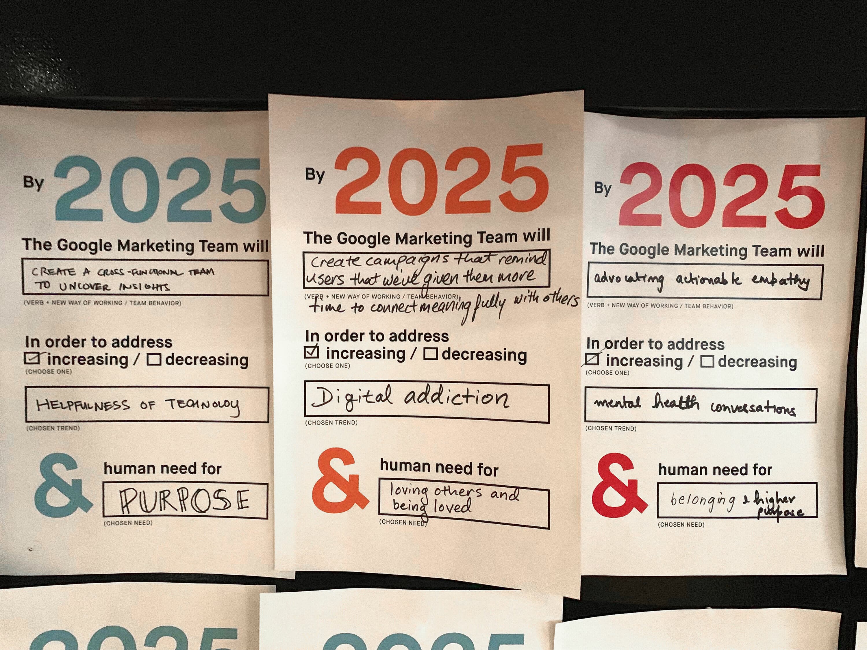 Three posters from the "Google Marketing Team" display 2025 goals. Left: Increase helpfulness of technology and prioritize "PURPOSE." Middle: Decrease digital addiction, increase loving others and being loved, and mental health. Right: Decrease automatic algorithms use.