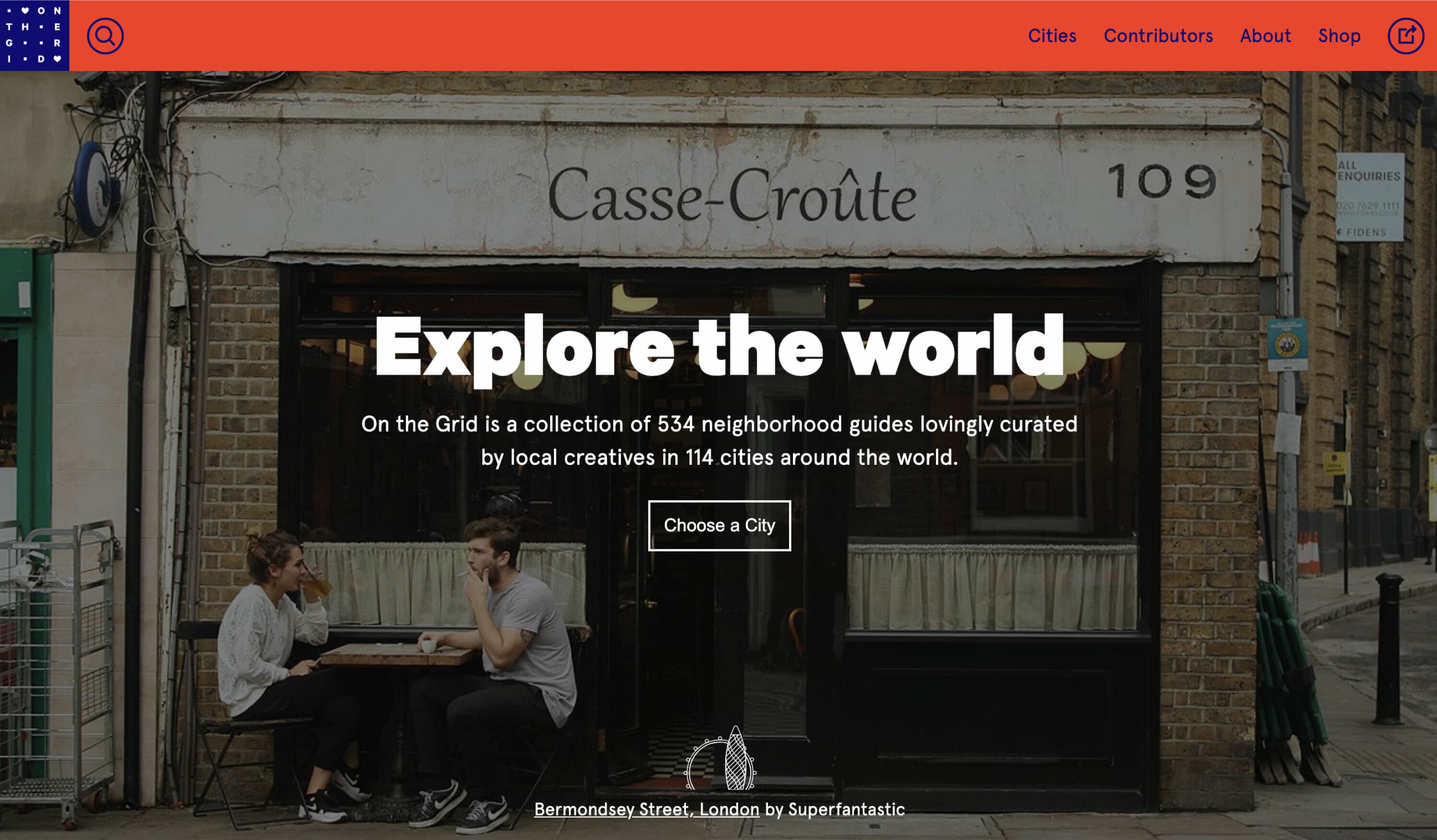 Two people sit at a table outside Casse-Croûte, a quaint restaurant at 109 Bermondsey Street, London. The webpage titled "Explore the world" offers a collection of 534 neighborhood guides curated by local creatives in 114 cities globally.