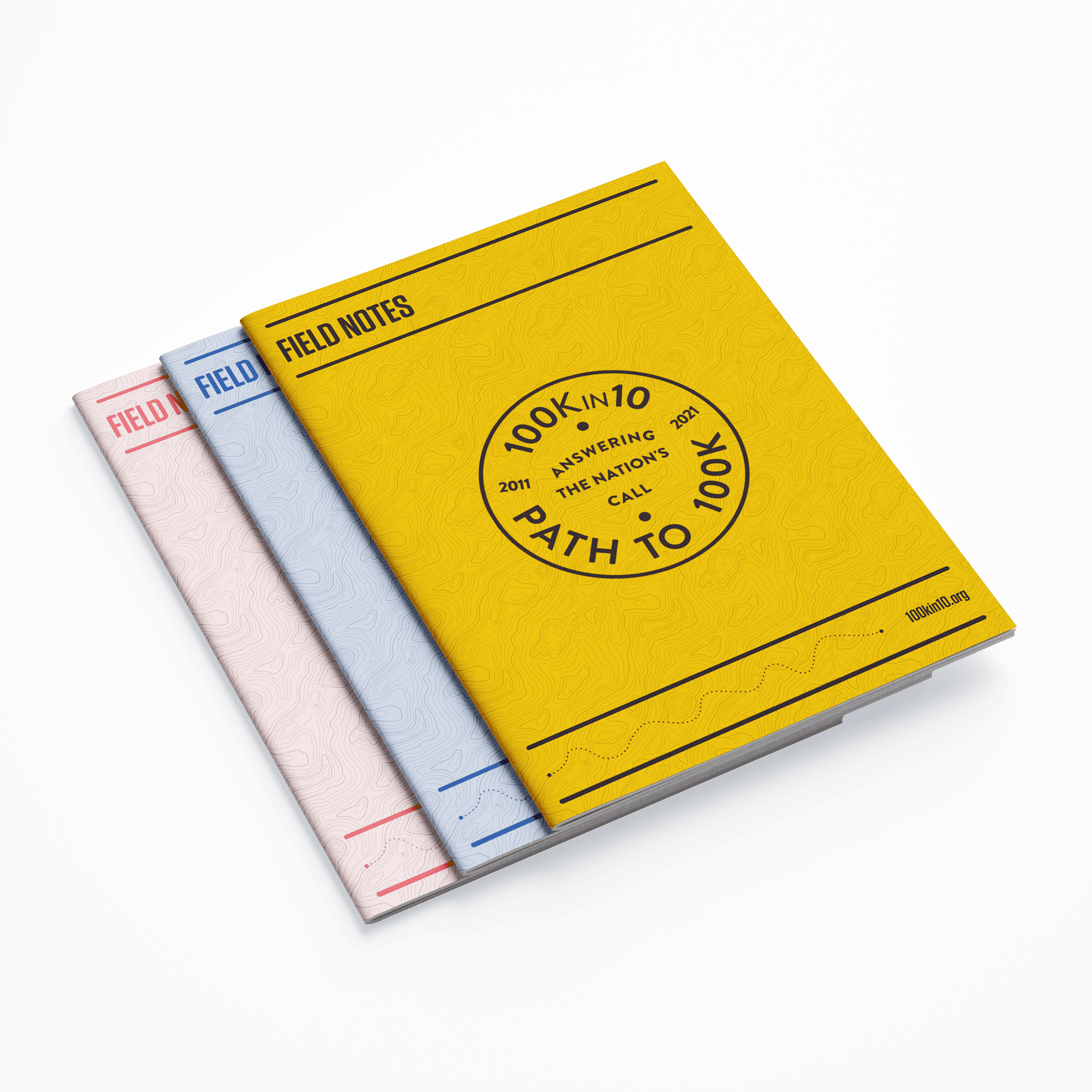 Three Field Notes booklets are stacked on a gray surface. The top one is yellow with the text “100K in 10: Answering the Nation’s Call” and “Path to 100K”. The middle one is white with a blue spine, and the bottom one is gray with a red spine.
