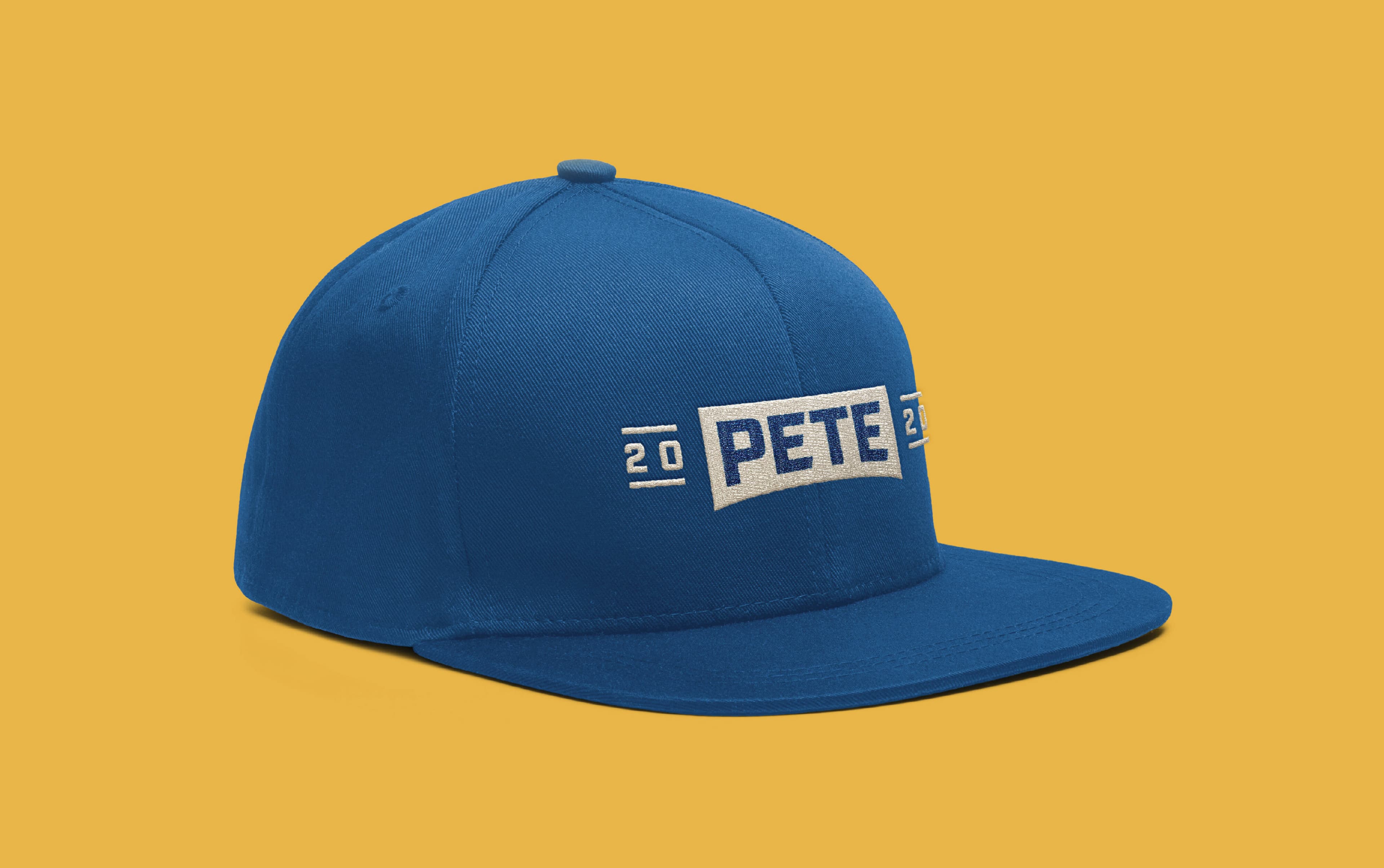 A blue baseball cap with a flat bill is displayed against a yellow background. The cap features the text "PETE" embroidered in white, along with the numbers "20" situated on either side of the text.