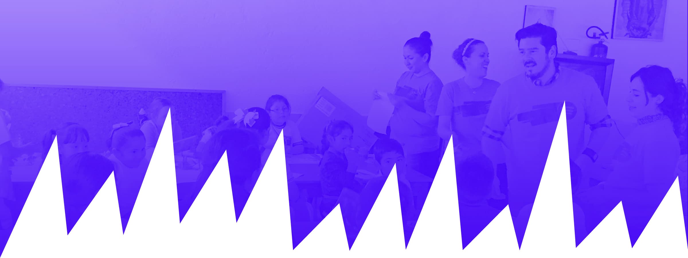 A group of children and adults are engaged in a classroom activity. The image has a purple color overlay with a jagged white design at the bottom, resembling mountains or sound waves. The adults appear to be guiding or instructing the children.