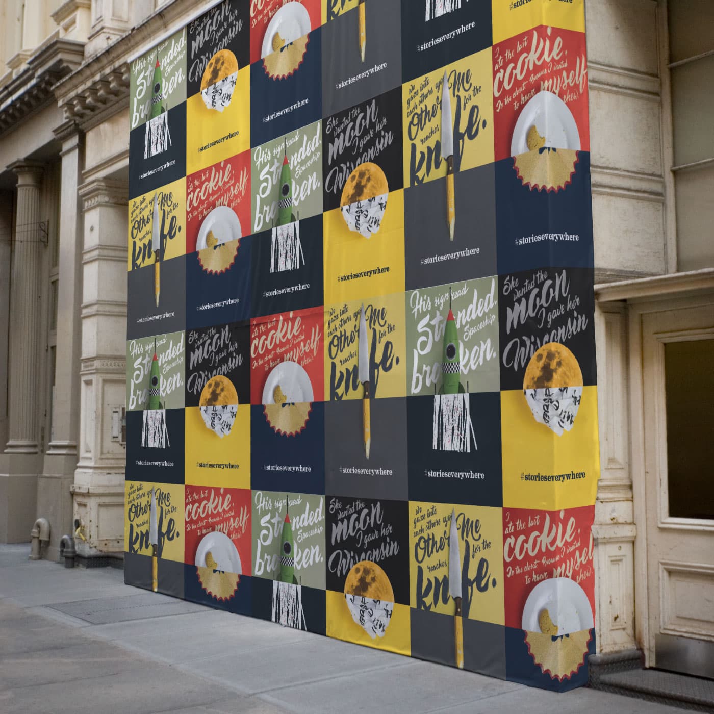 A building facade is covered with a large, colorful grid of posters. The posters display various phrases, such as "The other side of the knife" and "and when the mold of the cookie is over here." The background colors alternate between yellow, black, and red.