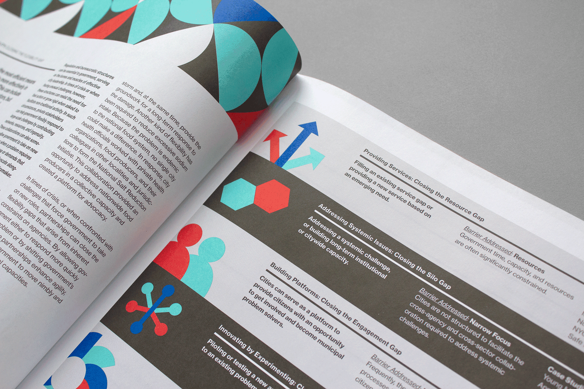 An open magazine displaying a page with various diagrams, charts, and text. The design includes colorful geometric shapes like circles, arrows, and hexagons in teal, blue, red, and grey. The page appears to discuss strategies and solutions, possibly in a business or technical context.