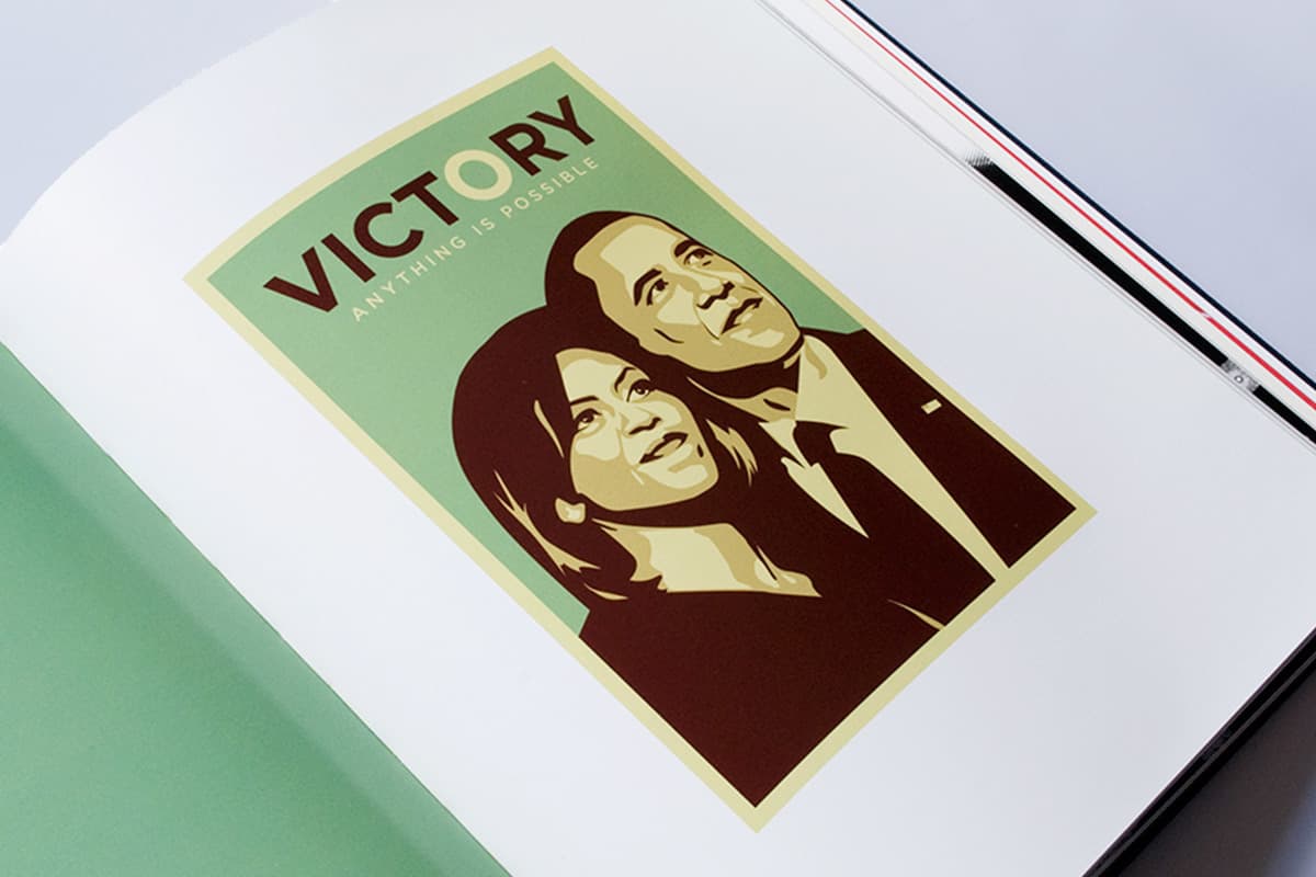 A book is open to a page displaying a stylized poster featuring two people looking upward. Above them, the word "VICTORY" is boldly written, and below it reads, "ANYTHING IS POSSIBLE." The poster design uses shades of brown, green, and cream.
