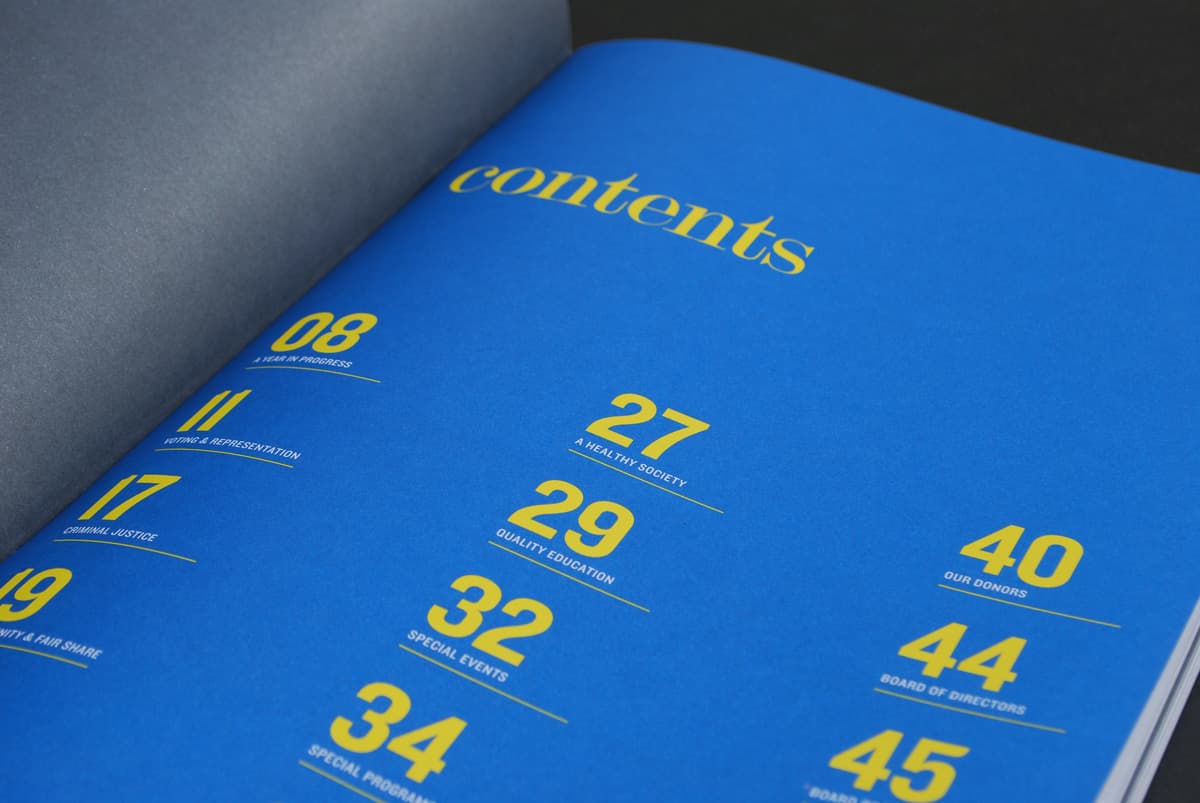 Close-up of a blue contents page in a magazine or book. The page features a list of sections with corresponding page numbers in bold yellow text. Some visible sections include "A Sneak Preview," "A Vibrant Society," "Quality Education," and "Our Donors.