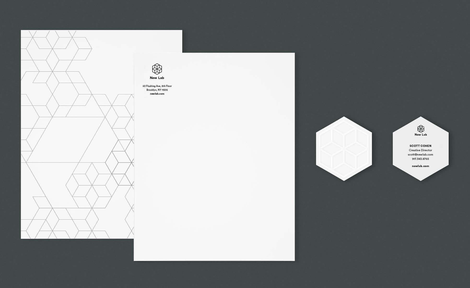 A modern stationery set on a dark background. It includes two sheets of letterhead paper with hexagonal geometric designs in the background and a minimalist logo and address at the top left. Also shown are two hexagon-shaped business cards with similar designs.