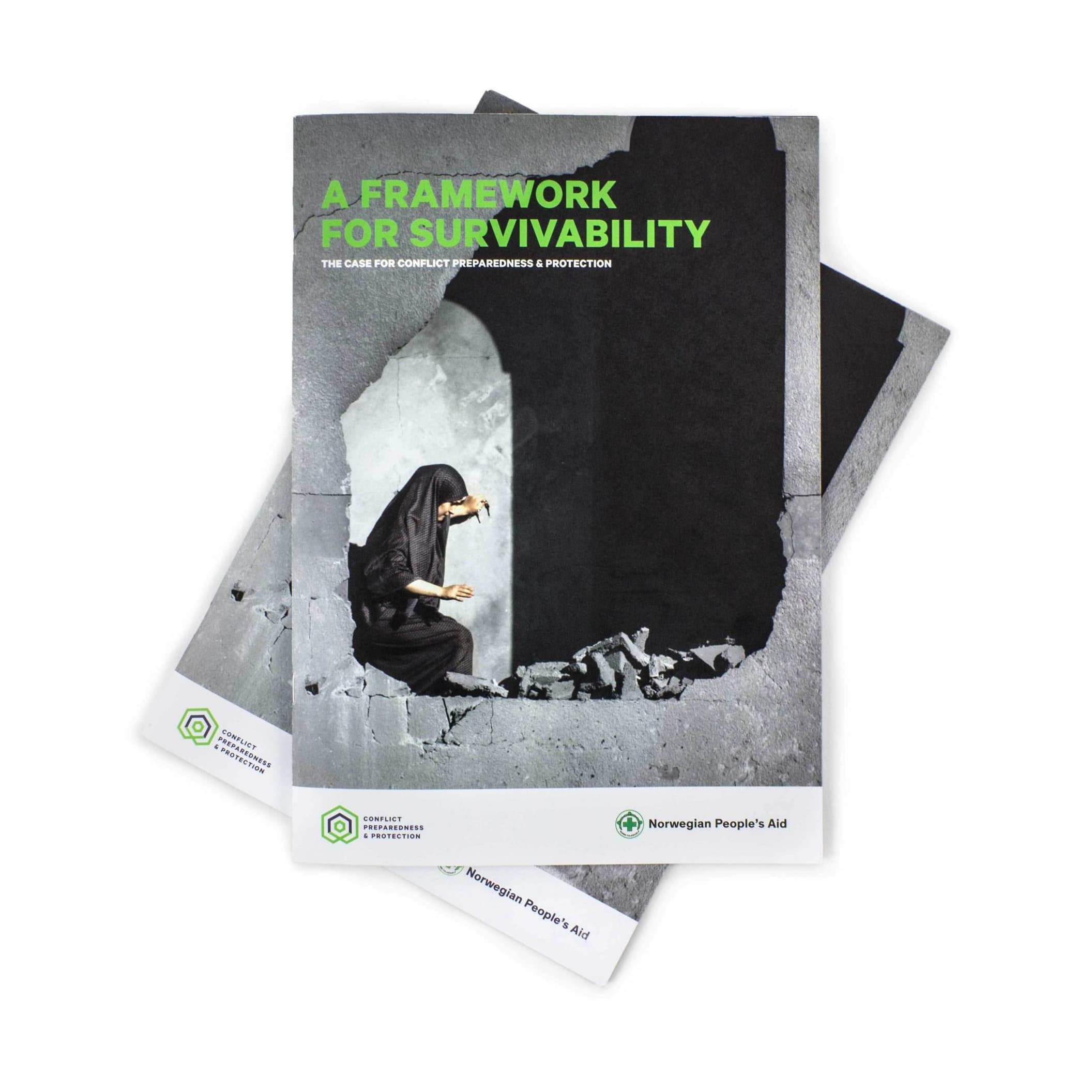 A booklet titled "A Framework for Survivability: The Case for Conflict Preparedness & Protection" from the Norwegian People's Aid lies on top of another identical booklet. The cover features an image of a person in a dark robe surrounded by rubble.