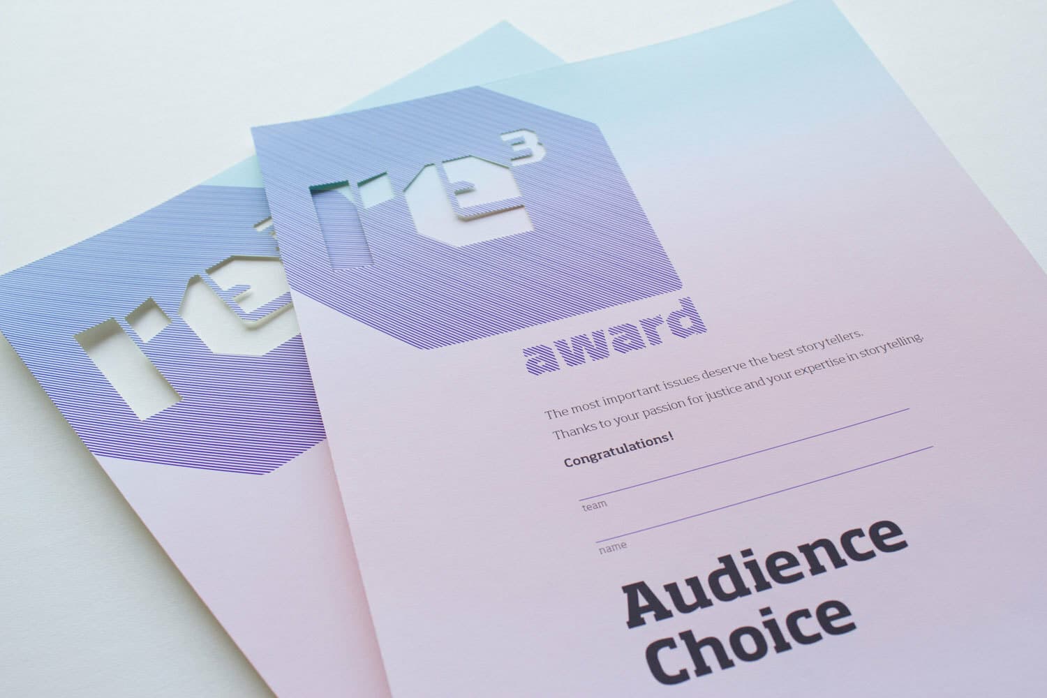 Two certificates with a gradient color scheme, overlaying each other. The top part features a geometric design with the text "re³ award." The body contains the words, "The most important issues achieve the best storytellers. Thanks to your passion for facts and your expertise in storytelling," with blank spaces for a name and category "Audience Choice.