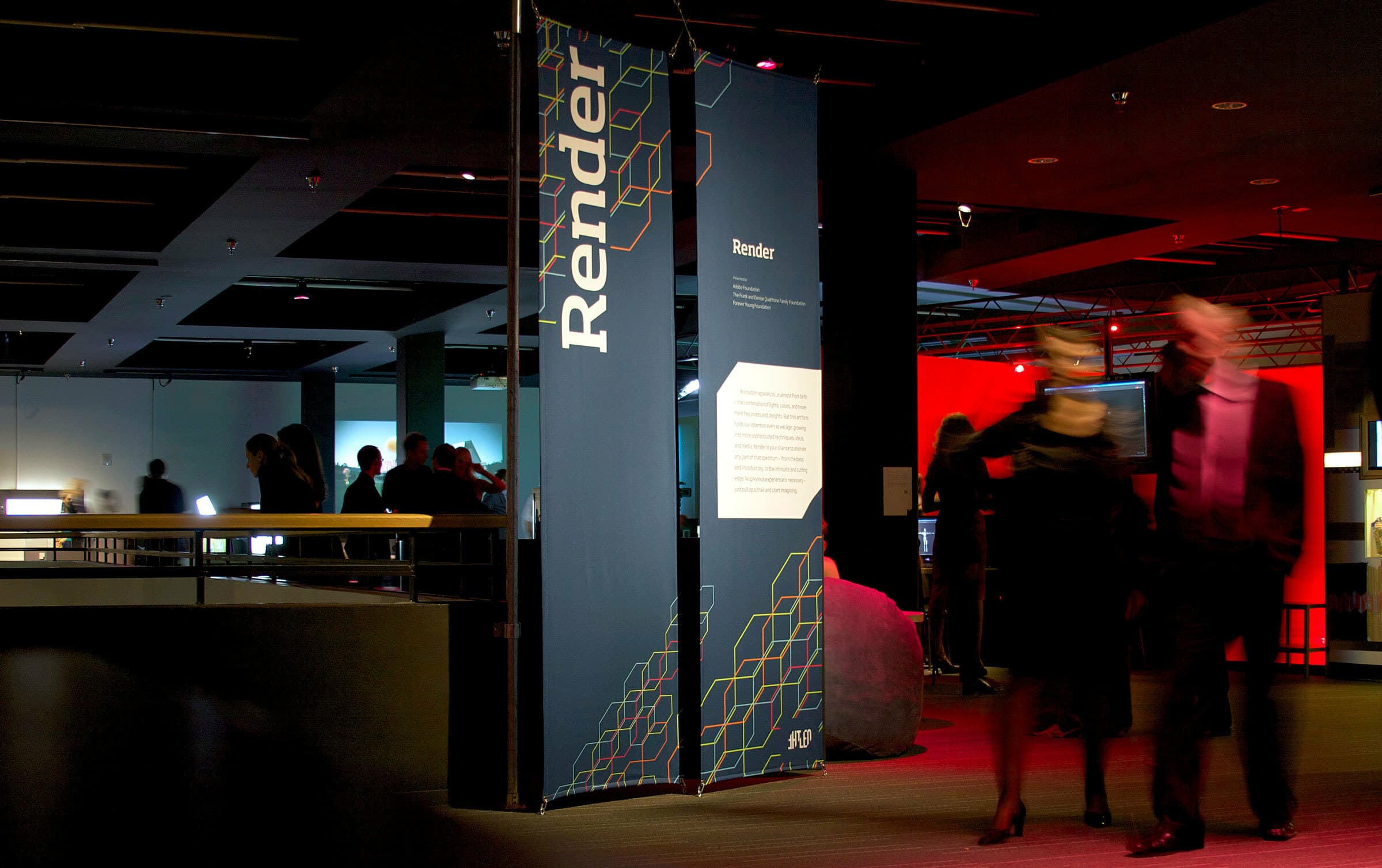 People walk by an exhibition display in a dimly lit gallery. The display features a prominent sign with the word "Render" and geometric patterns. Other visitors can be seen in the background, examining various exhibits under focused lighting.
