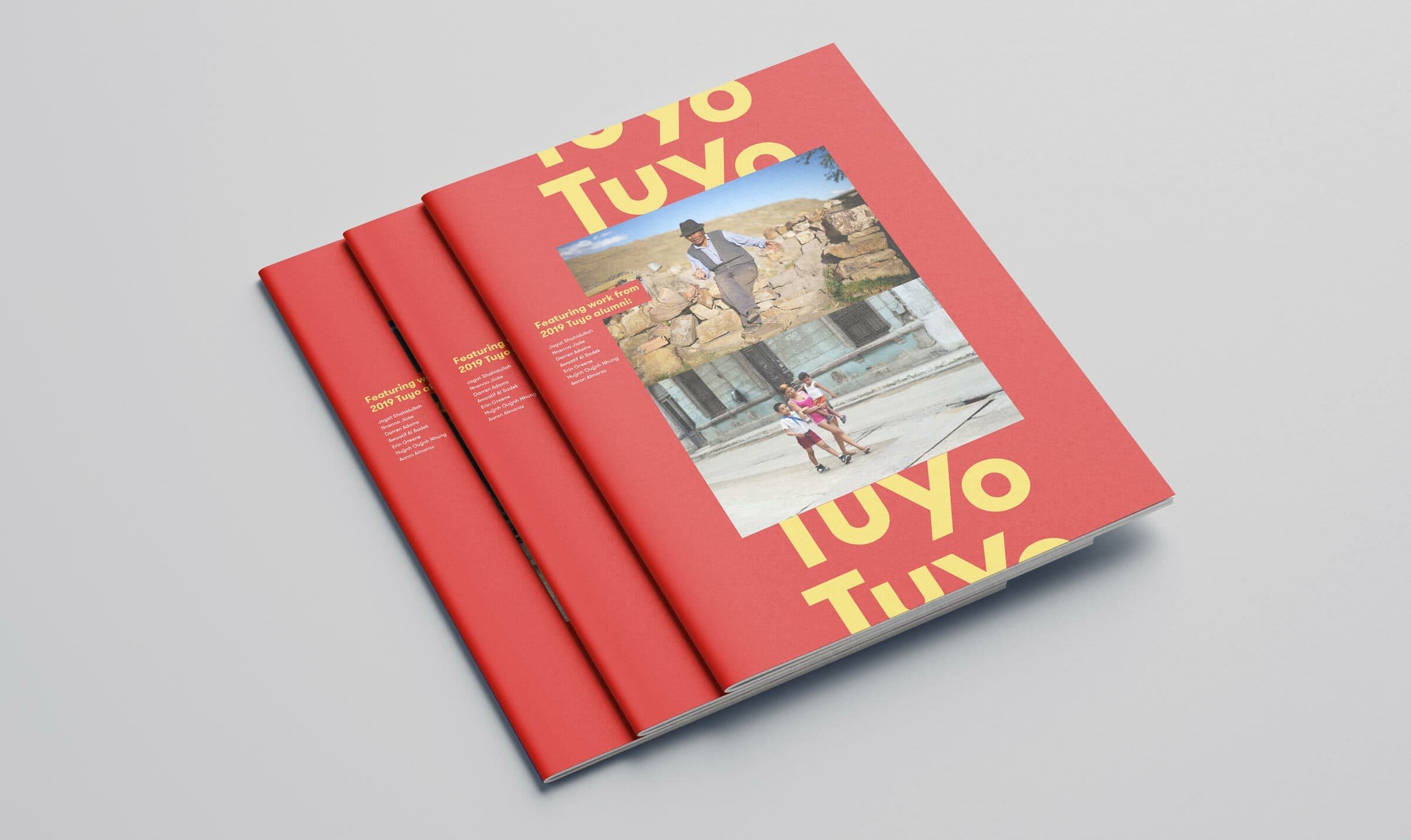 Three red-covered books titled "Tuyo Tuyo" are stacked in a fan arrangement. The cover features bold yellow letters and an image of a man in traditional attire alongside a child, set against a backdrop of stone structures and a clear blue sky.