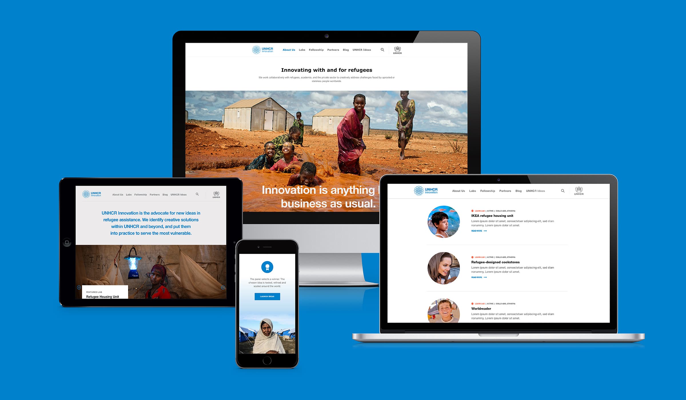 A group of devices including a desktop computer, laptop, tablet, and smartphone displaying a website related to refugee support, featuring images of refugees, news articles, and information about educational initiatives. The background is a solid blue color.