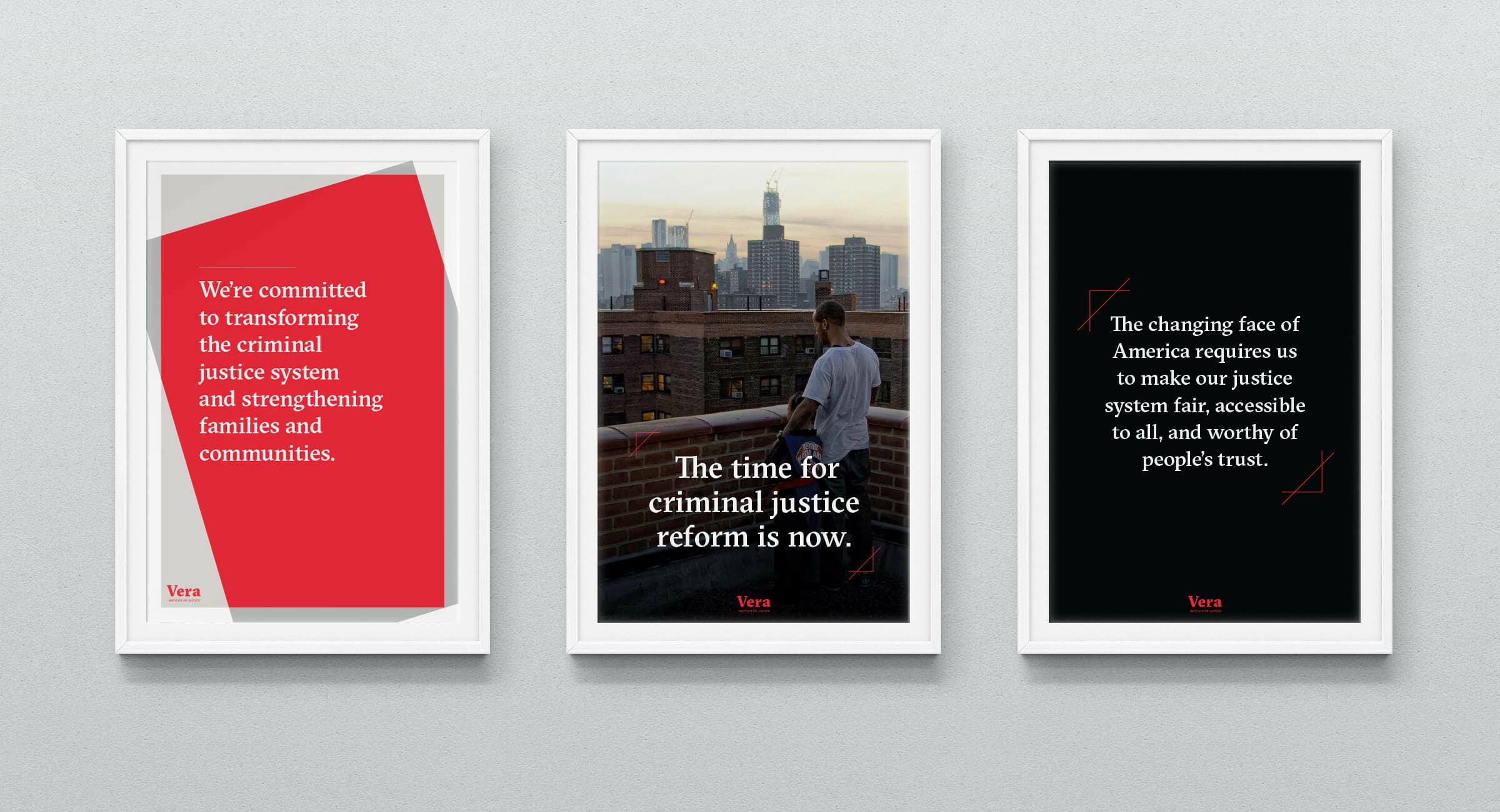 Three framed posters on a wall. The left poster has a red background with text about transforming the criminal justice system. The middle poster shows a person overlooking a cityscape with text about criminal justice reform. The right poster has a black background with text about making the justice system fairer. Both the left and right posters feature the word "Vera" at the bottom.