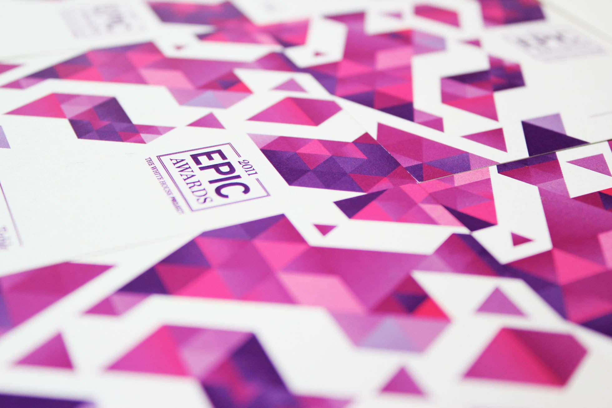 A close-up of purple and pink geometric-patterned brochures or flyers for the "EPIC Awards 2017." The design features a mix of triangles and polygons, creating a vibrant and dynamic appearance. The text "EPIC Awards 2017" is prominently displayed.